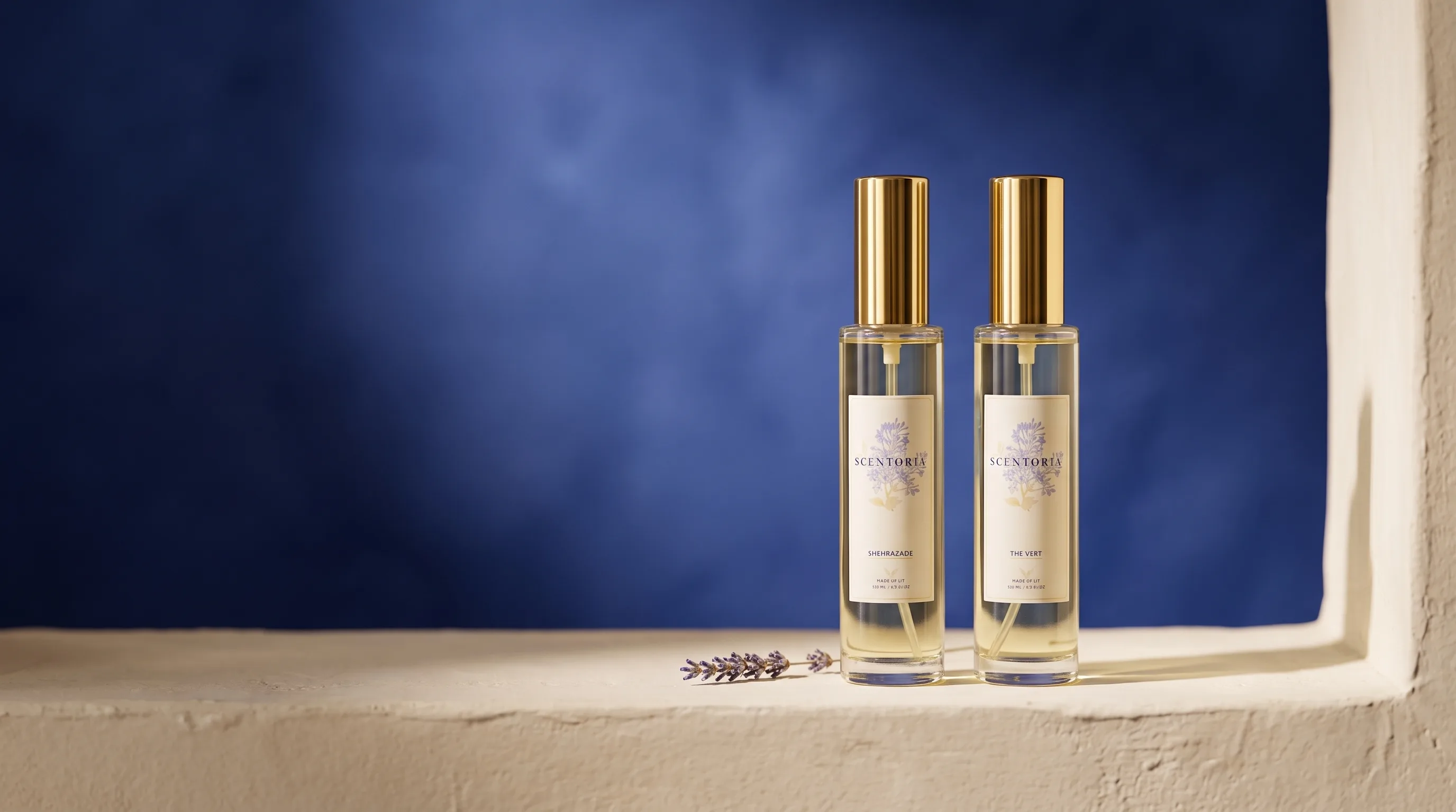 Scentoria home fragrance sprays on a cream sill against deep royal-blue plaster